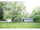 Charming one-story home featuring a spacious front yard and mature shade tree at 4023 Cedar Hills South Dr, Greenwood, IN 46143