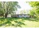 Well-kept single-story home with lush green lawn and mature shade trees, providing a tranquil setting at 4023 Cedar Hills South Dr, Greenwood, IN 46143