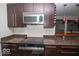 The gourmet kitchen includes stainless appliances, granite counters and dark wood cabinetry at 4023 Cedar Hills South Dr, Greenwood, IN 46143