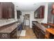 An open kitchen includes stainless appliances, granite counters and dark wood cabinetry at 4023 Cedar Hills South Dr, Greenwood, IN 46143