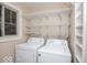 A laundry room equipped with a washer, dryer, and wire shelving for efficient storage at 4023 Cedar Hills South Dr, Greenwood, IN 46143