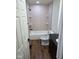 Clean bathroom with a tub and shower combination and with hardwood flooring and tiled walls at 4115 Tansel Rd, Indianapolis, IN 46234