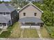 An aerial view shows the two-story home with a large, covered front porch at 418 Harlan St, Indianapolis, IN 46201