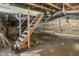 Unfinished basement featuring concrete block walls, ductwork, and wooden stairs at 418 Harlan St, Indianapolis, IN 46201