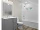 Bathroom featuring updated vanity, plank flooring, shower-tub with modern fixtures, and a bright interior at 418 Harlan St, Indianapolis, IN 46201