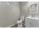 Modern bathroom features a white toilet, vanity with a mirror and wood-style flooring at 418 Harlan St, Indianapolis, IN 46201