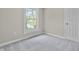 Bright bedroom with a large window, light neutral paint, modern door, and plush carpet at 418 Harlan St, Indianapolis, IN 46201