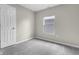 A bright bedroom with gray carpet, a window, and a white door at 418 Harlan St, Indianapolis, IN 46201
