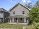 Two-story home featuring a covered front porch with sturdy wood pillars at 418 Harlan St, Indianapolis, IN 46201