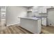 Cozy kitchen with white cabinets, granite counters, island, and sleek wooden floors at 418 Harlan St, Indianapolis, IN 46201
