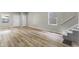 Open-concept living area with laminate floors, staircase, and natural light from the windows at 418 Harlan St, Indianapolis, IN 46201