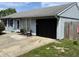 Exterior view of home showing blue siding, a black garage door and small seating area at 5117 Bahia Dr, Indianapolis, IN 46237