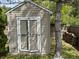 Exterior view of backyard shed with a tree and stacked firewood nearby at 5117 Bahia Dr, Indianapolis, IN 46237