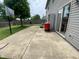 Spacious backyard featuring a concrete patio area, basketball hoop, and sliding glass doors at 5241 Waterton Lakes Dr, Indianapolis, IN 46237