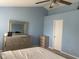 Bright bedroom with vaulted ceiling, light blue walls, and a gray dresser and mirror at 5241 Waterton Lakes Dr, Indianapolis, IN 46237