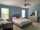 Bright bedroom featuring light blue walls, neutral carpet, a ceiling fan, and a large bed with a decorative headboard at 5241 Waterton Lakes Dr, Indianapolis, IN 46237