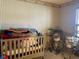 Bedroom features striped wallpaper with crib and a drumset at 5241 Waterton Lakes Dr, Indianapolis, IN 46237