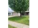 Well-maintained front yard with a mature tree, adding shade and character to the property at 5241 Waterton Lakes Dr, Indianapolis, IN 46237