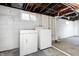 Unfinished basement features a white washer and dryer, with utility connections and a small window at 5809 N Illinois St, Indianapolis, IN 46208
