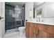 This bathroom offers a modern vanity with a wooden cabinet and a walk-in shower with dark tiling at 5809 N Illinois St, Indianapolis, IN 46208