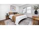 A stylish bedroom includes a queen bed, decorative pillows, wood accents and a patterned rug at 5809 N Illinois St, Indianapolis, IN 46208