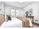 A cozy bedroom with a queen bed features natural light and neutral decor for a relaxing ambiance at 5809 N Illinois St, Indianapolis, IN 46208