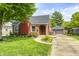 Charming brick home with manicured lawn, beautiful landscaping, and a detached one car garage at 5809 N Illinois St, Indianapolis, IN 46208