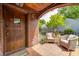 A cozy covered front porch with wicker furniture and a decorative brick archway at 5809 N Illinois St, Indianapolis, IN 46208