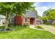 Charming brick home featuring a well-manicured lawn, mature tree, and delightful landscaping at 5809 N Illinois St, Indianapolis, IN 46208