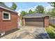 A detached one car garage with a brown door and an alley entrance on a sunny day at 5809 N Illinois St, Indianapolis, IN 46208