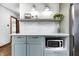 This kitchen has custom cabinets, quartz countertops, modern lighting and stainless steel microwave at 5809 N Illinois St, Indianapolis, IN 46208