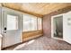 The sunroom has wood floors, half brick walls, and windows all around to let light in at 5809 N Illinois St, Indianapolis, IN 46208