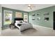 Spacious bedroom with green walls, ceiling fan, and two bright windows at 5850 Lyster Ln, Indianapolis, IN 46239