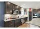 Modern kitchen with dark cabinetry, stainless steel appliances, and bright countertops offers a functional design at 5850 Lyster Ln, Indianapolis, IN 46239