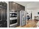Well-appointed kitchen featuring stainless appliances including built-in oven and refrigerator and wood flooring at 5850 Lyster Ln, Indianapolis, IN 46239