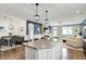 Open-concept living space with dining and Gathering areas with island and modern lighting at 5850 Lyster Ln, Indianapolis, IN 46239
