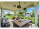Covered patio featuring an outdoor table set and grill overlooking a landscaped yard and shed at 5850 Lyster Ln, Indianapolis, IN 46239