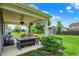 Covered patio features outdoor seating and views of the well-maintained backyard and blue skies at 5850 Lyster Ln, Indianapolis, IN 46239