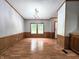 Bright living room featuring wood-look flooring, paneled walls, large windows, and decorative lighting fixture at 6538 N Tutterow Rd, Monrovia, IN 46157