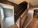 Carpeted staircase featuring wooden banister leading to a living space and a kitchen at 660 White Ash Trail, Mooresville, IN 46158