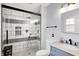 This modern bathroom has a vanity with marble top, a toilet, and walk-in shower with black and white tile at 6605 Grosvenor Pl, Indianapolis, IN 46220