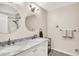 This bathroom features double sinks with marble countertop, round mirrors, and a shower over tub combo at 6605 Grosvenor Pl, Indianapolis, IN 46220