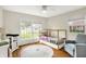Bright bedroom features wood floors, a ceiling fan, a single bed, a changing table, and a comfortable chair at 6605 Grosvenor Pl, Indianapolis, IN 46220