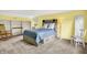Bright bedroom features built in shelves, carpet flooring, unique headboard and is painted in a welcoming yellow hue at 6605 Grosvenor Pl, Indianapolis, IN 46220