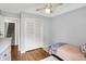 This bedroom has hardwood floors, a ceiling fan, a twin bed and closet with bi-fold doors at 6605 Grosvenor Pl, Indianapolis, IN 46220