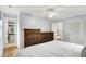 This light blue bedroom includes hardwood floors, two wooden dressers, and a view of the bathroom at 6605 Grosvenor Pl, Indianapolis, IN 46220