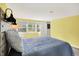 A bright bedroom featuring carpeted floors, large windows, and a modern bed with a distinctive headboard at 6605 Grosvenor Pl, Indianapolis, IN 46220