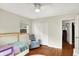 This bedroom features wood floors, a ceiling fan, a single bed, a comfortable chair, and a closet at 6605 Grosvenor Pl, Indianapolis, IN 46220
