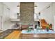 Open-concept dining room features a stone fireplace, hardwood floors, and a vaulted ceiling at 6605 Grosvenor Pl, Indianapolis, IN 46220