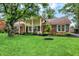 Well-maintained home with manicured lawn, mature trees and brick and wood trim at 6605 Grosvenor Pl, Indianapolis, IN 46220